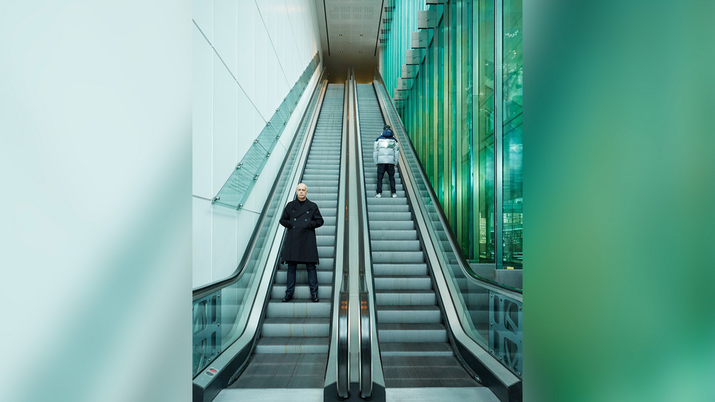 Neil Tennant und Chris Lowe von Pet Shop Boys auf langen Rolltreppen