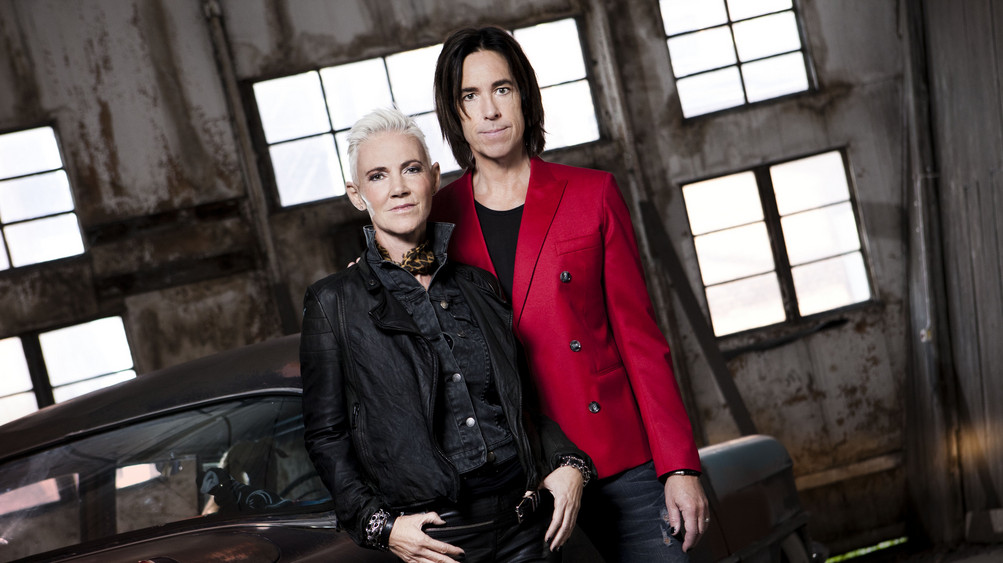Roxette stehen in einer alten Halle vor einem Auto